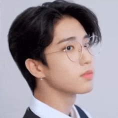 a close up of a person wearing glasses and a suit and tie .
