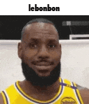 a man with a beard is wearing a yellow jersey and smiling .