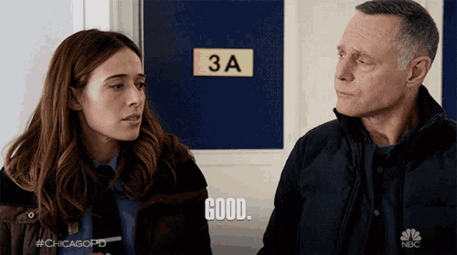 a man and a woman standing in front of a door that says 3a on it