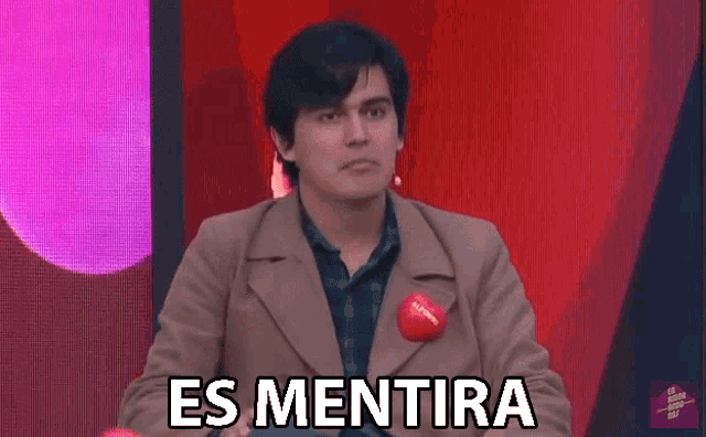 a man in a brown coat is holding a red ball and says es mentira