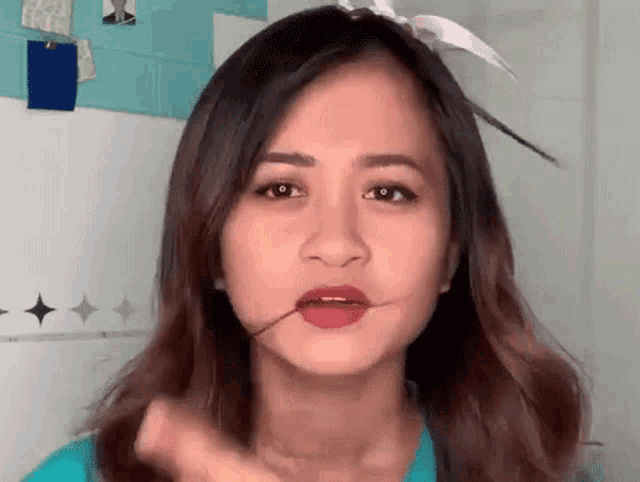 a woman is making a funny face with a toothpick in her mouth .