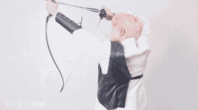 a young man with pink hair is holding a bow and arrow in front of a sign that says vogueme