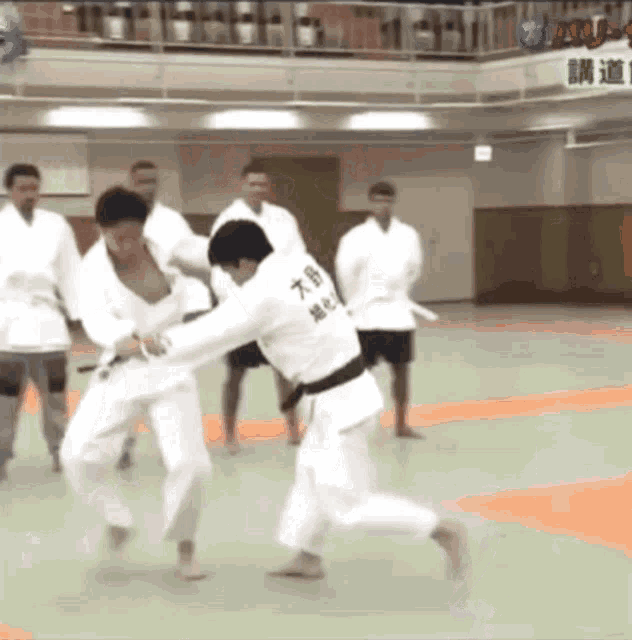 a man in a white karate uniform has the letter t on the back