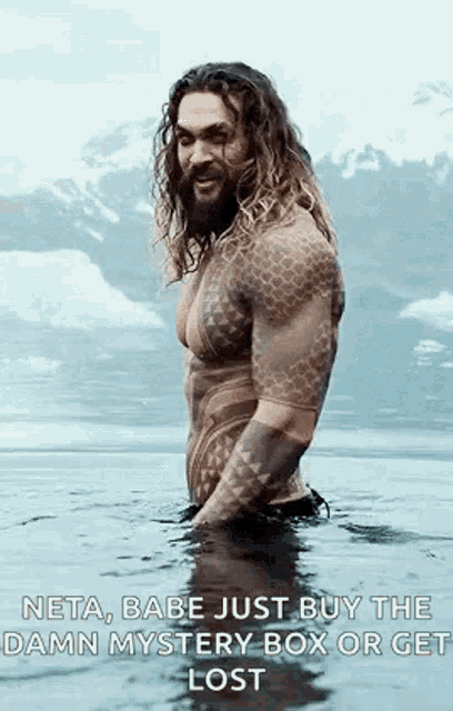 a man with a beard and tattoos is standing in the water .