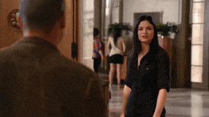a man and a woman are standing in a hallway looking at each other