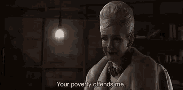 a woman in a fur coat is standing in a dark room and talking to someone .