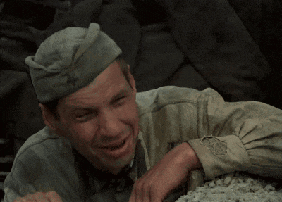 a man wearing a hat with a red star on it is crying