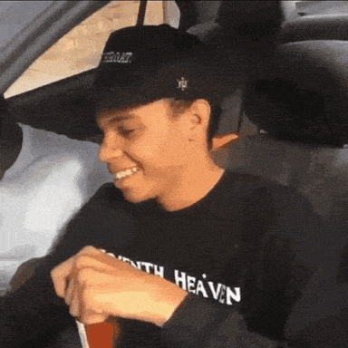 a man wearing a shirt that says south heaven is sitting in a car