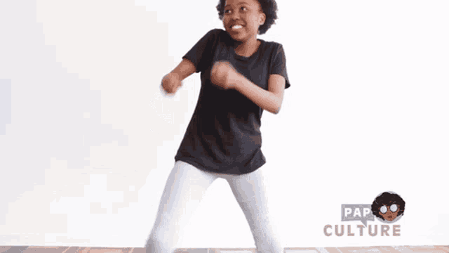 a woman in a black shirt is dancing in front of pap culture
