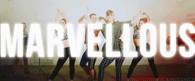 a group of people are standing in front of the word marvellous