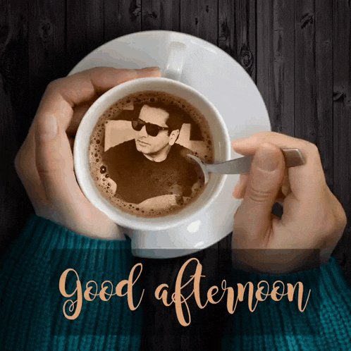 a person holding a cup of coffee with a picture of a man in it and the words good afternoon