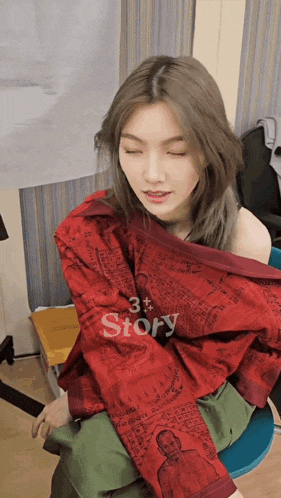 a woman wearing a red jacket that says story on the sleeves