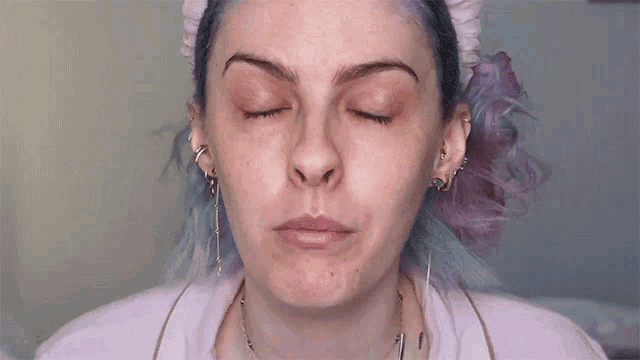 a woman with purple hair is wearing a headband and says xodozin on her face