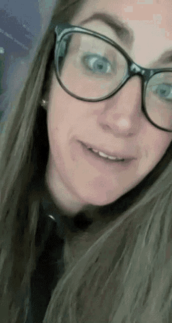 a close up of a woman wearing glasses and a black shirt .
