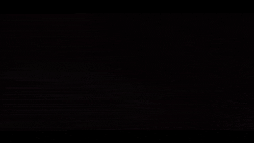 a close up of a person 's mouth with a sharp tooth in the dark with a light behind it .
