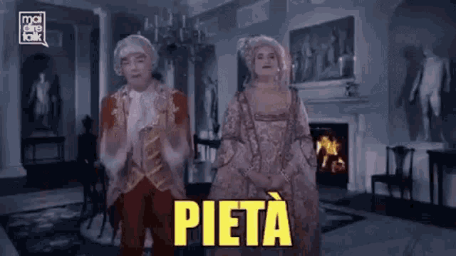 a man and a woman in historical costumes are standing in a living room with the word pieta in yellow letters .