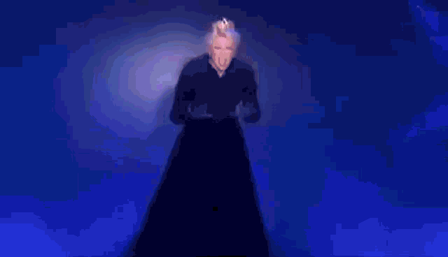 a woman in a white dress with a crown on her head is screaming on a stage