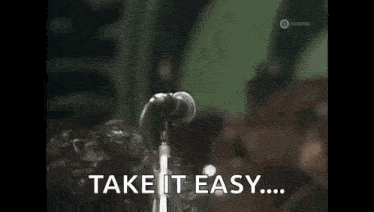 a man is singing into a microphone and saying `` take it easy ... ''