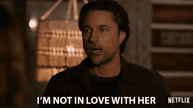 a man is standing in front of a lamp and saying `` i 'm not in love with her '' .