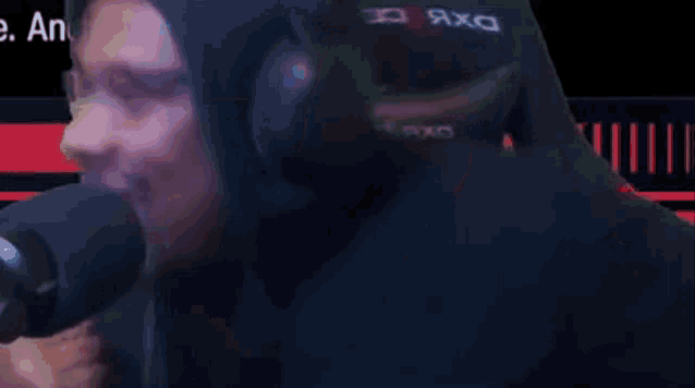 a man wearing headphones is sitting in front of a microphone and making a face .