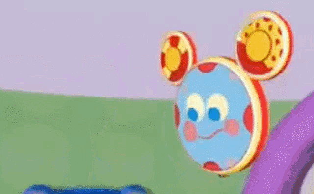 a cartoon mickey mouse is holding a mirror and a tambourine in his hands .