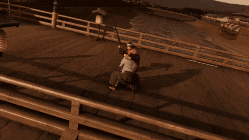 a man is holding a woman in his arms on a bridge over a body of water