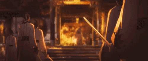 a person holding a sword in front of a fire