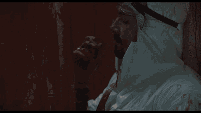 a man in a white protective suit with blood coming out of his mouth