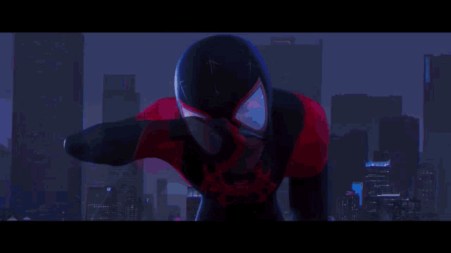 a man in a spider man costume is standing in front of a city skyline at night