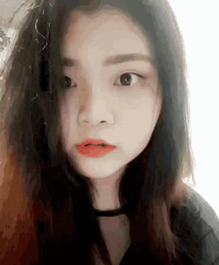 a close up of a woman 's face with long hair and red lips