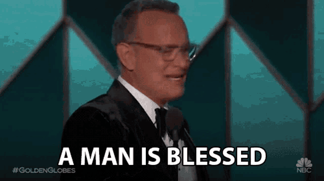 a man in a tuxedo and bow tie is giving a speech at a golden globes awards .