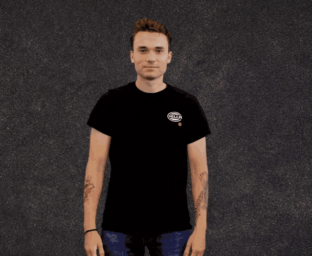 a man wearing a black t-shirt that says hella giving a peace sign