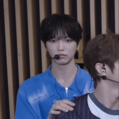 a man wearing a blue shirt has a microphone on his ear