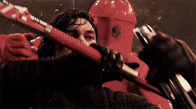 a man in a red helmet is holding a red stick in his hand .