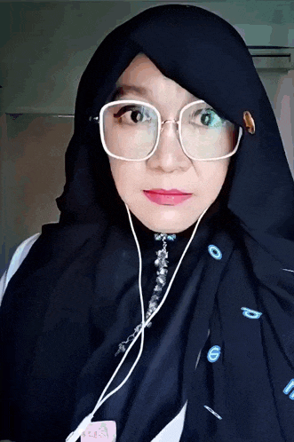 a woman wearing glasses and a scarf has the number 6 on it