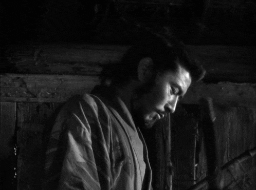 a black and white photo of a man with a beard looking at the camera