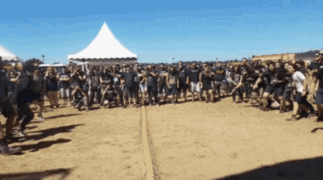 a group of people are standing in a field with a tent in the background