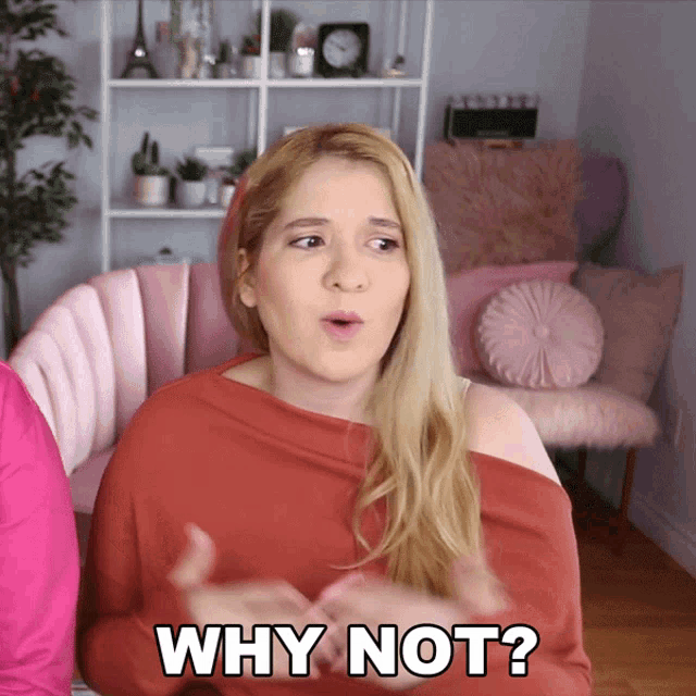 a woman says why not in front of a pink couch