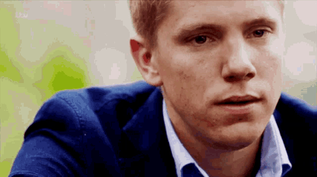 a close up of a man 's face with itv written on the bottom left