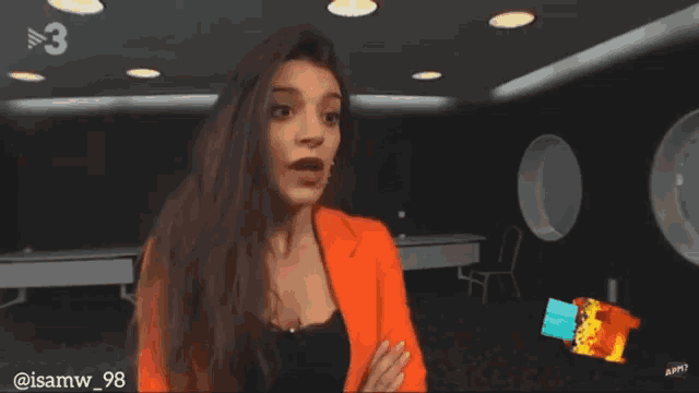 a woman in an orange jacket with the number 3 on the bottom