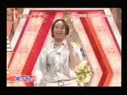 a woman in a silver shirt is dancing on a stage .