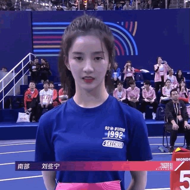 a woman wearing a blue shirt that says 1992 on it