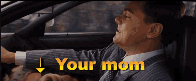 a man in a suit and tie is driving a car and says " your mom "