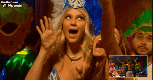 a woman wearing a blue and white feathered headdress stands in front of a screen that says bandisoft.com @ mirando