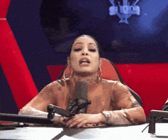 a woman is sitting in front of a microphone with a sign in the background that says ' snoop dogg ' on it