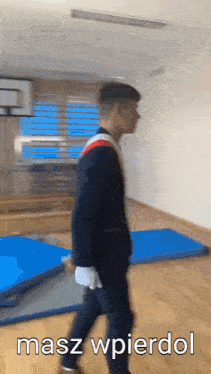 a man in a suit is walking in a room with the words masz wpierdol written on the bottom