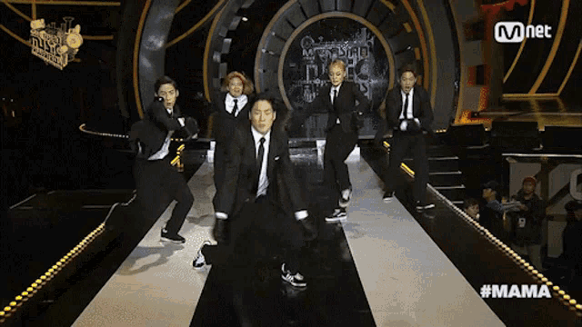 a group of people are performing on a stage with the hashtag #mama