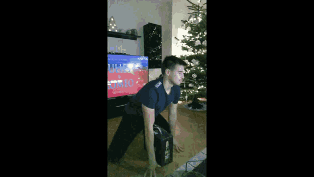 a man in front of a tv that says christmas