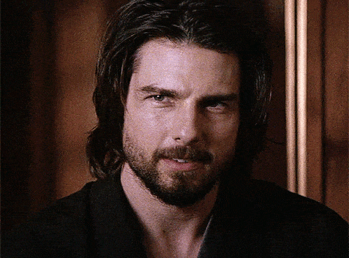 a man with long hair and a beard is smiling for the camera