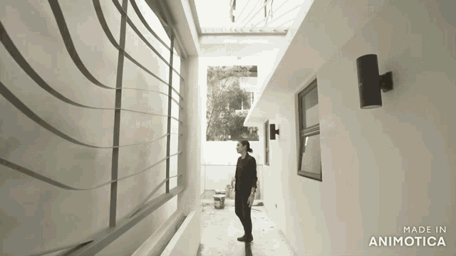 a woman is standing in a hallway with the words made in animotica on the bottom